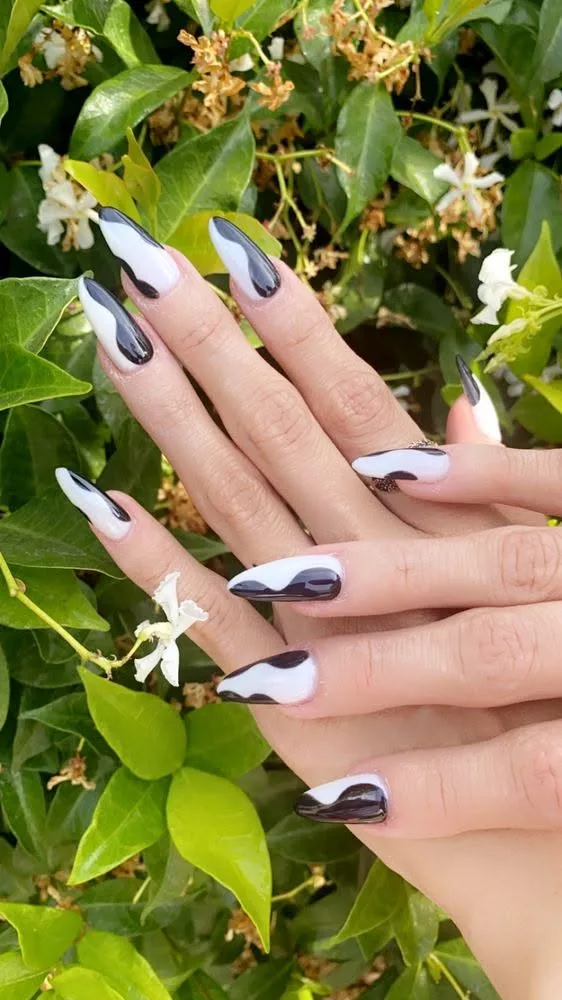 Almond nails with abstract black-and-white swirl art.