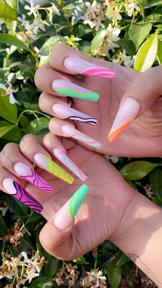 Long coffin nails with vibrant neon swirl nail art.